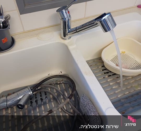 ברז מים זורם, צינורות וכלי ניקוי בכיור מטבח